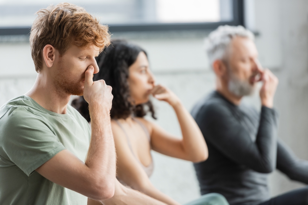 Redhead,Man,Practicing,Nostril,Breathing,Near,Blurred,Group,In,Yoga